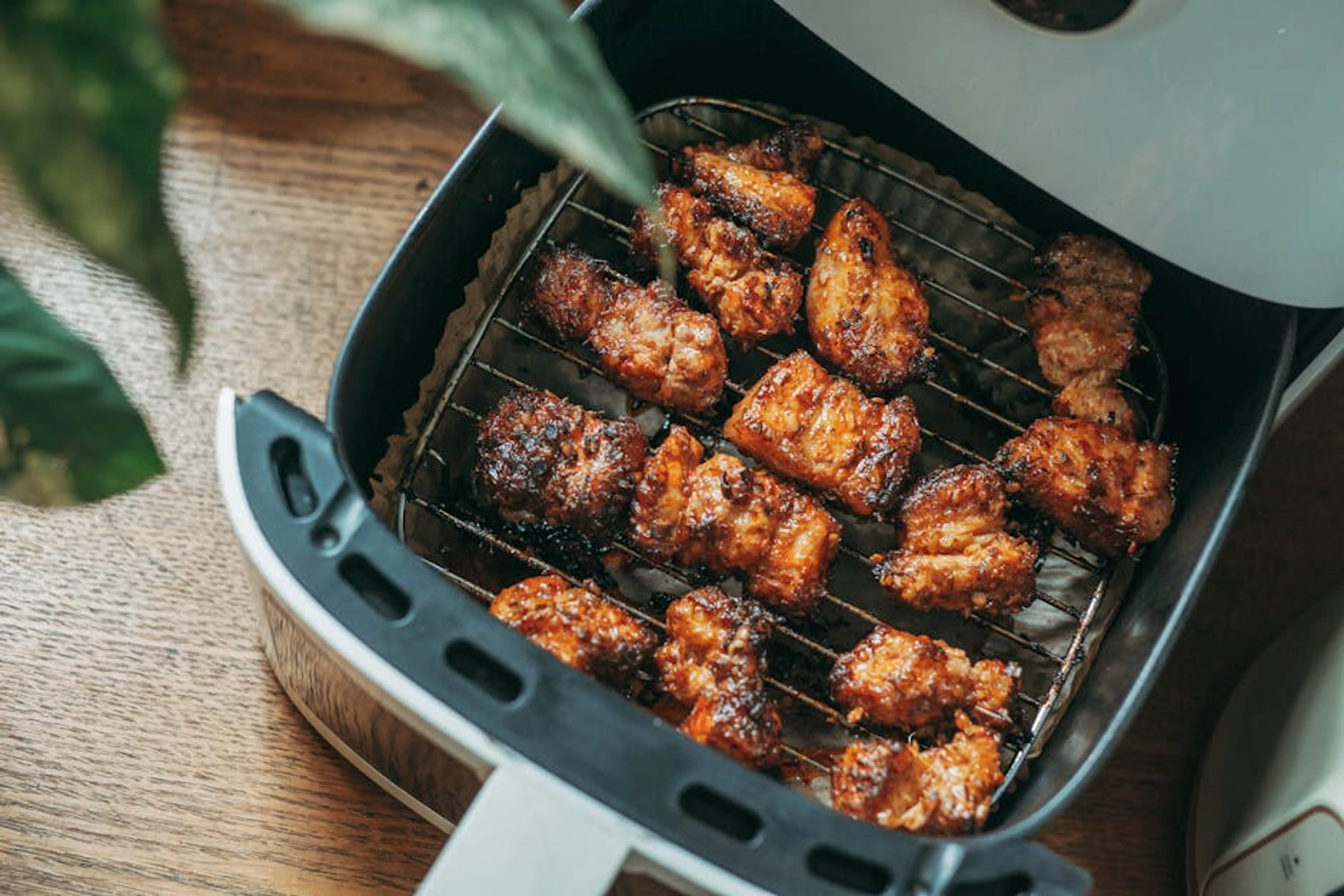 Delicious crispy chicken pieces cooked perfectly in a modern air fryer, ready to serve. Crispy chicken wings cooking in an air fryer basket