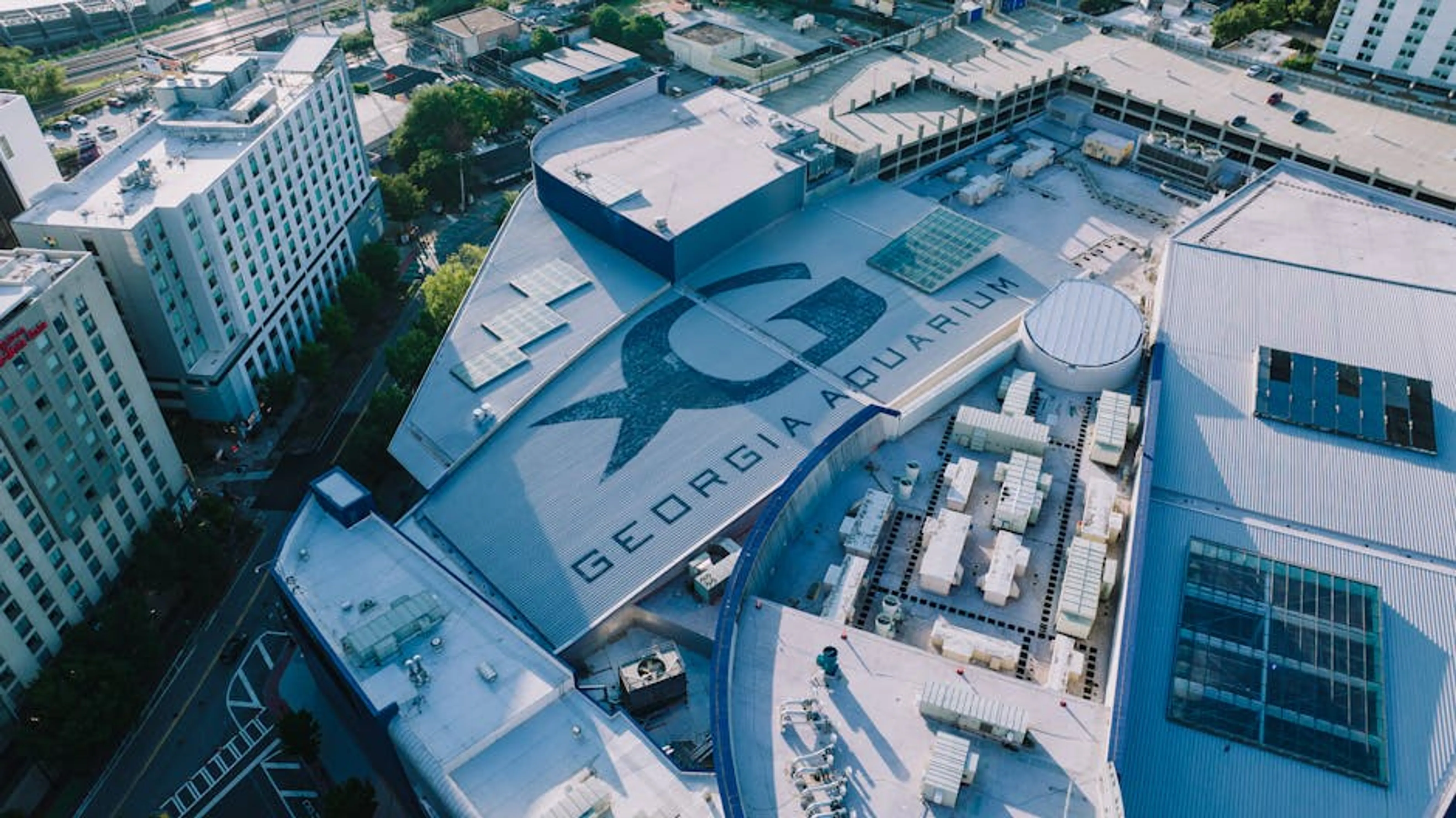 Stunning aerial shot of the Georgia Aquarium located in Atlanta, Georgia. Person researching fish species and tank sizes on a tablet for aquarium planning