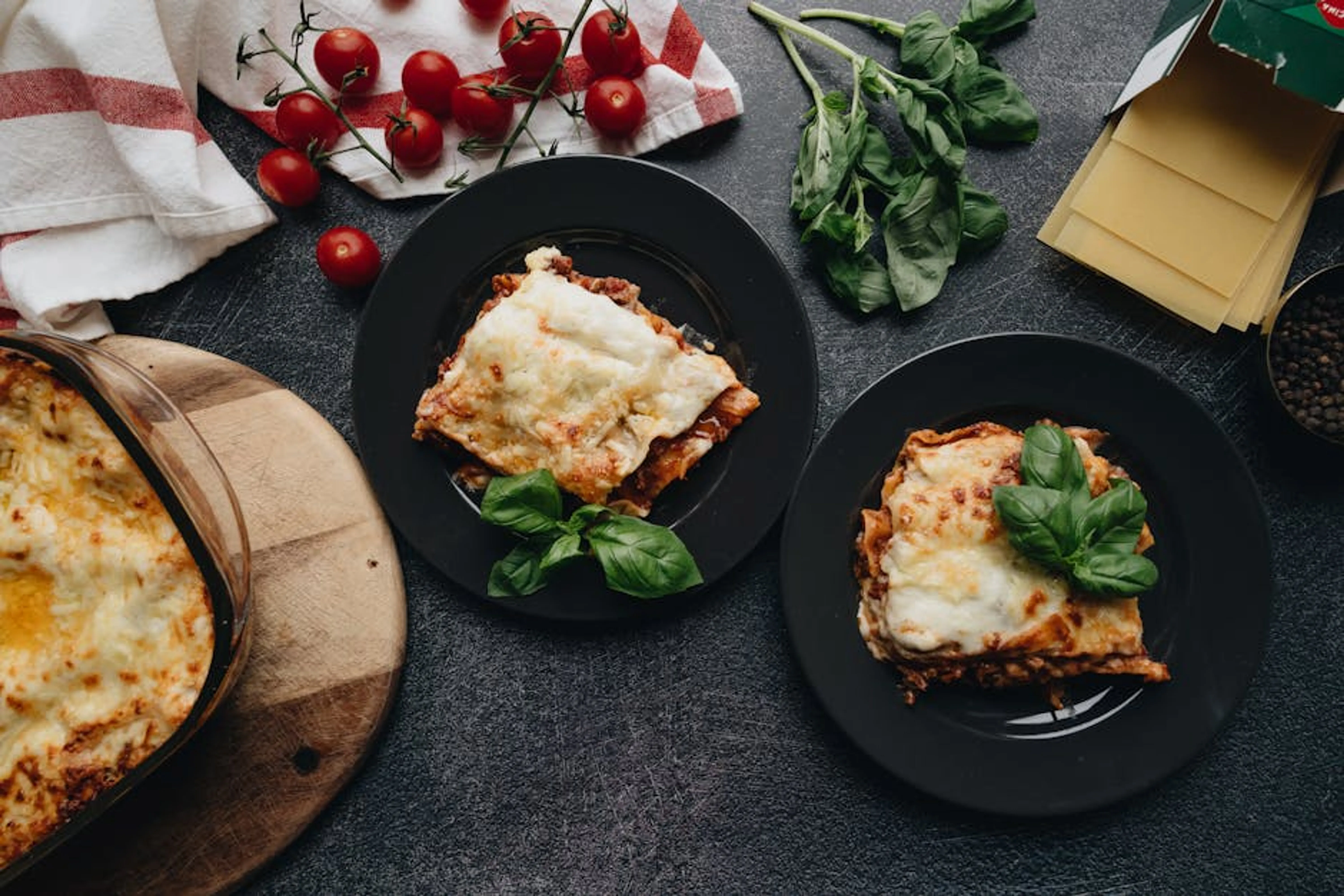 Delicious homemade lasagna served with fresh tomatoes and basil, perfect for Italian cuisine lovers. Assortment of fresh ingredients ready for quick weeknight dinners