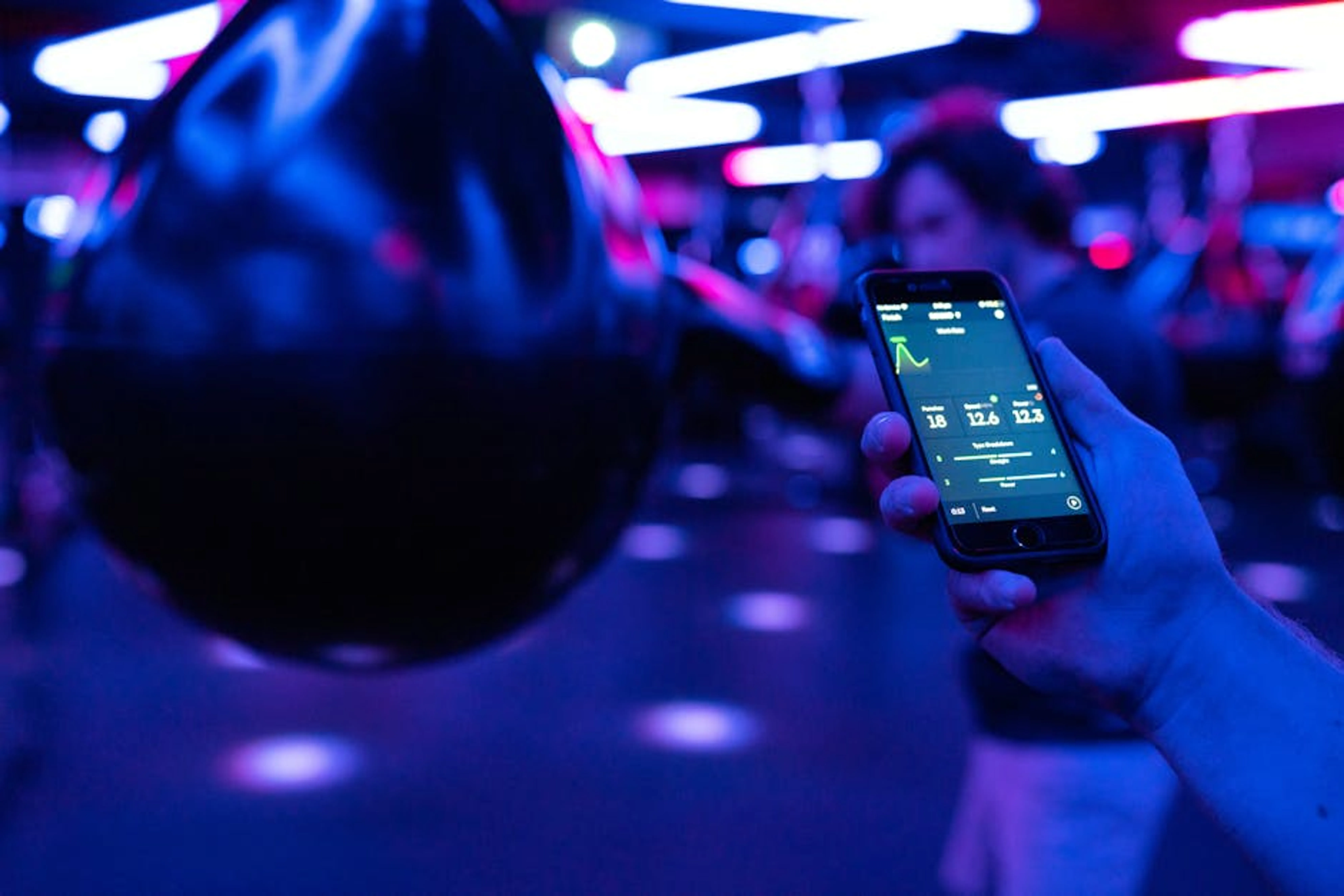 Smartphone displaying fitness tracking data next to boxing equipment under neon lighting. Smartphone displaying a sleep tracking app with sleep cycle data