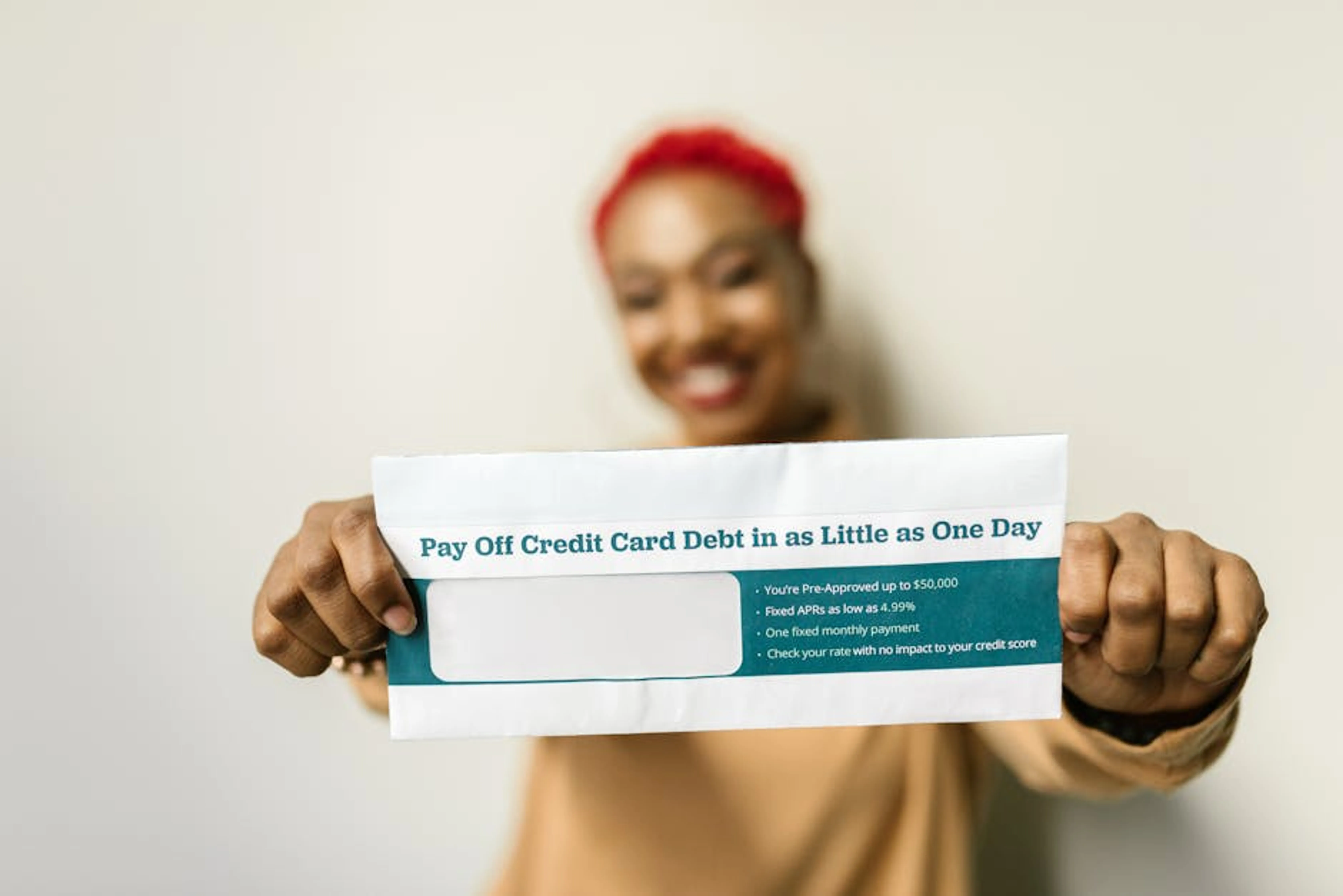 Woman presenting an envelope with a credit card debt offer, blurred background. Government building with text overlay 'Federal Direct Consolidation Loan'